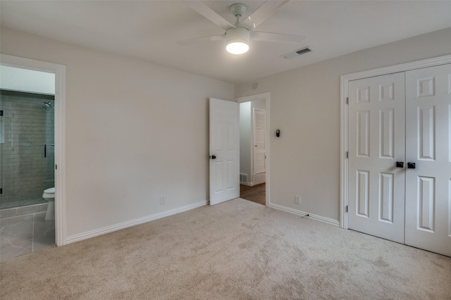 unfurnished bedroom featuring connected bathroom, ceiling fan, a closet, and light carpet