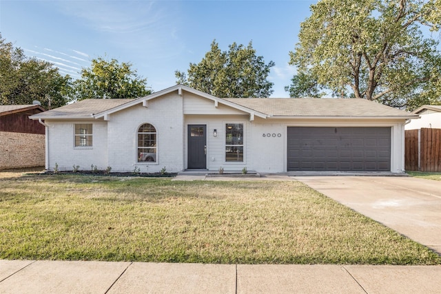 ranch-style house featuring a garage and a front lawn