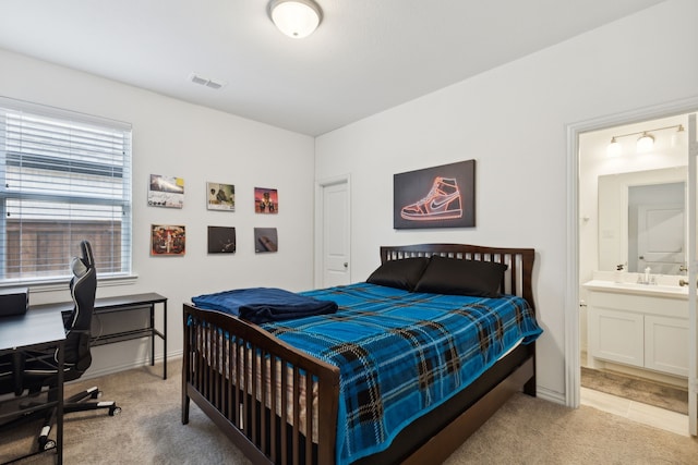 bedroom featuring light carpet and ensuite bath