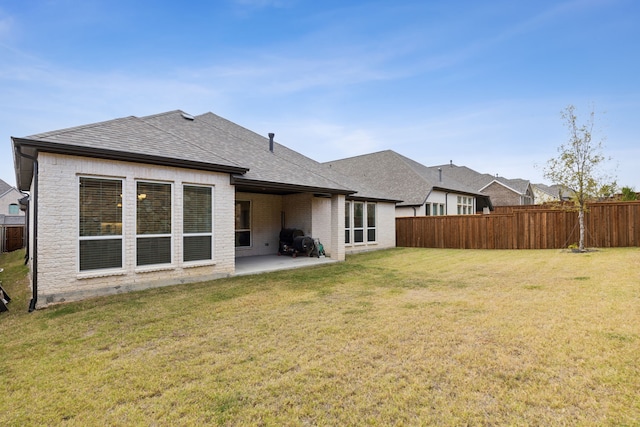 rear view of house with a yard and a patio area