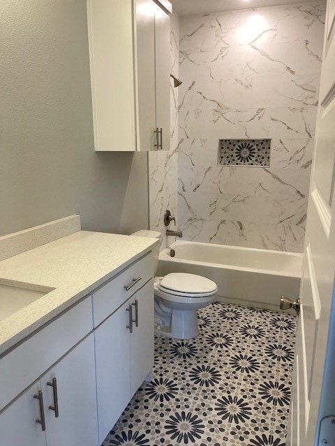 full bathroom with toilet, tiled shower / bath, vanity, and tile patterned flooring