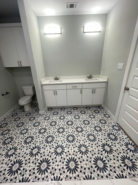 bathroom featuring vanity, toilet, and tile patterned flooring