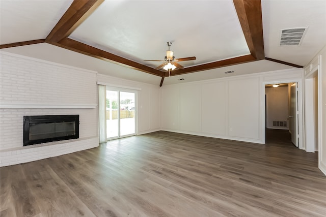 unfurnished living room featuring hardwood / wood-style floors, lofted ceiling with beams, a brick fireplace, and ceiling fan