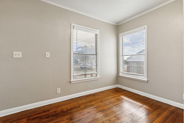 spare room with baseboards, ornamental molding, and dark wood-type flooring