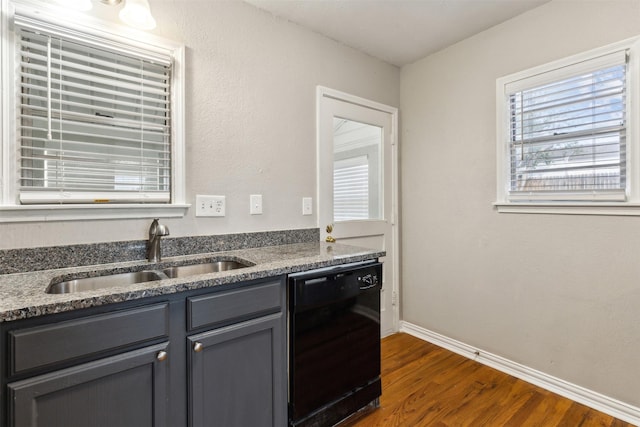 kitchen featuring baseboards, dark wood-style floors, a sink, dishwasher, and gray cabinetry