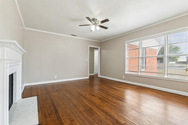 unfurnished living room with ceiling fan, a fireplace, wood finished floors, visible vents, and ornamental molding