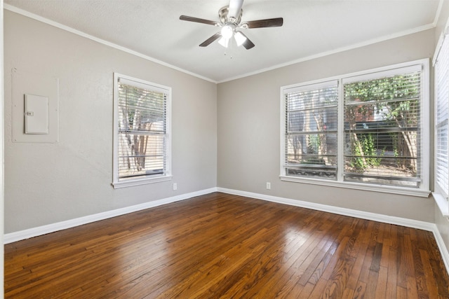 spare room with baseboards, ornamental molding, a ceiling fan, and dark wood-style flooring