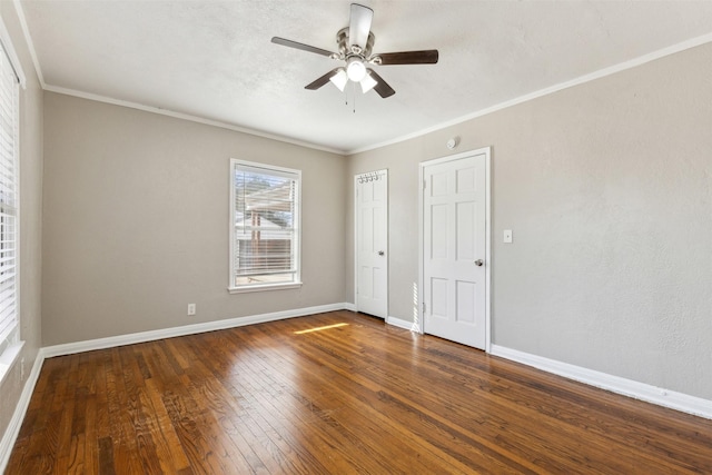 empty room featuring baseboards, ornamental molding, ceiling fan, and hardwood / wood-style floors