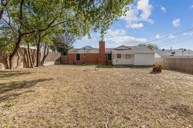 view of yard with a fenced backyard and a gate