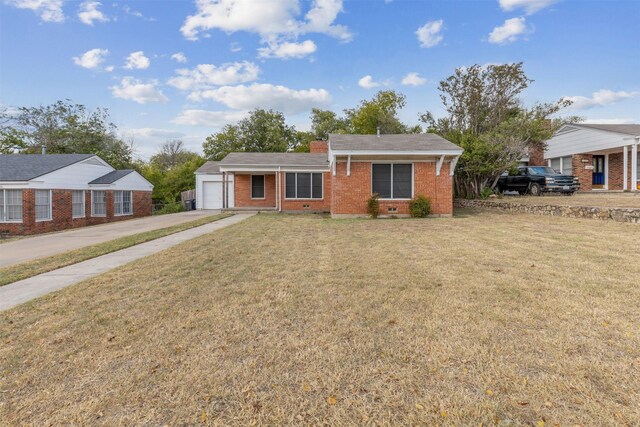 ranch-style house featuring a garage, covered porch, and a front lawn