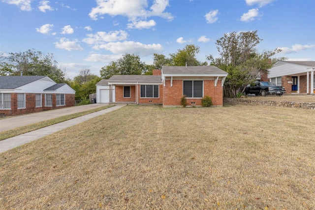 view of front of property with concrete driveway, brick siding, an attached garage, and a front lawn
