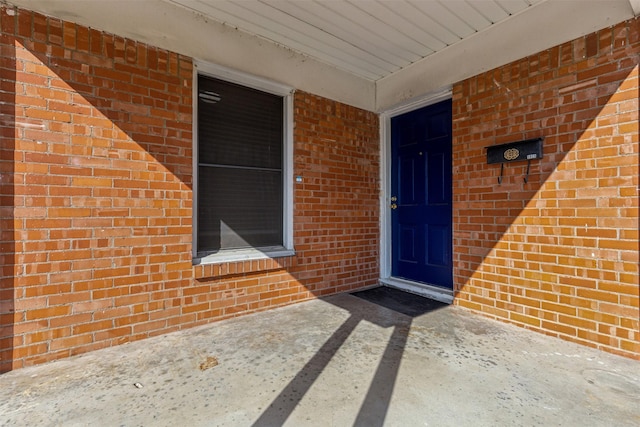 view of exterior entry featuring brick siding