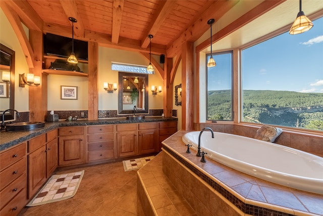 bathroom featuring tile patterned floors, wooden ceiling, tiled tub, vanity, and beam ceiling