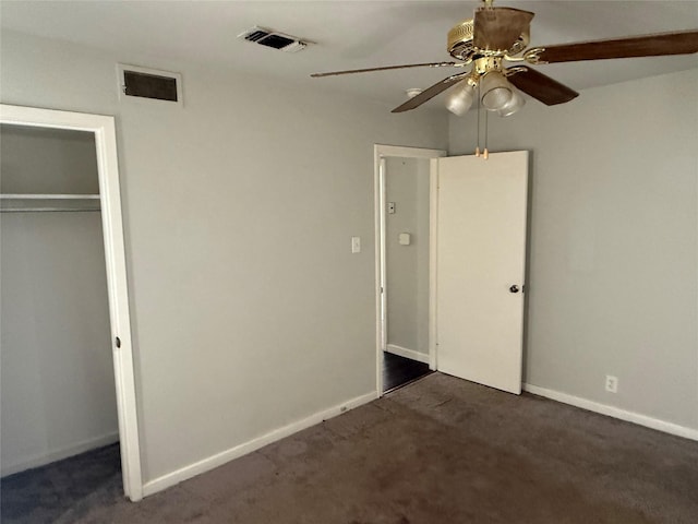 unfurnished bedroom with dark colored carpet, a closet, and ceiling fan