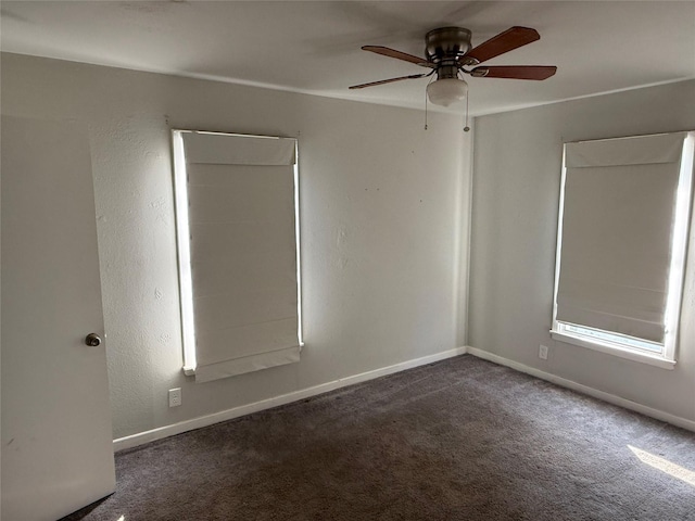 empty room with ceiling fan and dark carpet