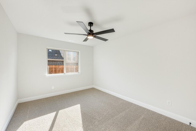 carpeted spare room with ceiling fan