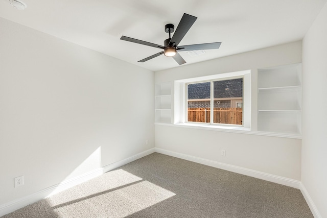carpeted spare room featuring ceiling fan