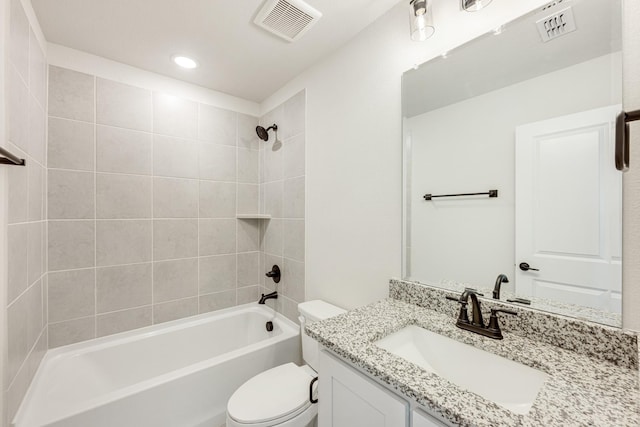 full bathroom with vanity, tiled shower / bath, and toilet