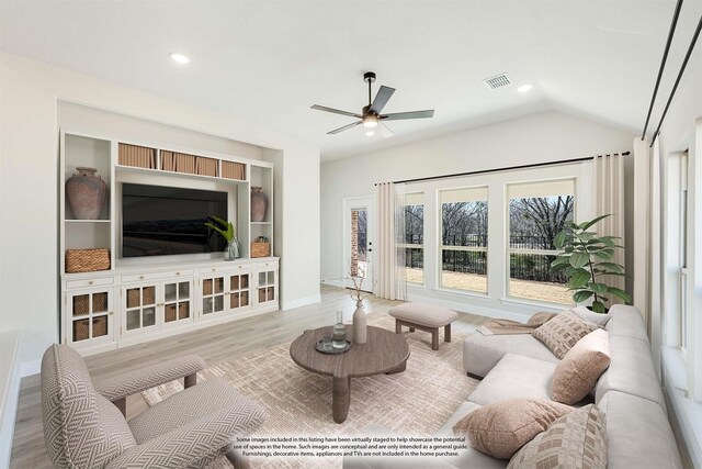 living room featuring ceiling fan, lofted ceiling, and light wood-type flooring