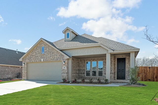 view of front of home with a garage, central AC, and a front lawn