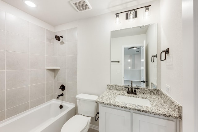 full bathroom with tiled shower / bath, vanity, and toilet