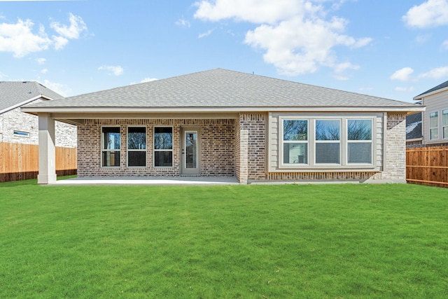 back of property with a patio and a lawn