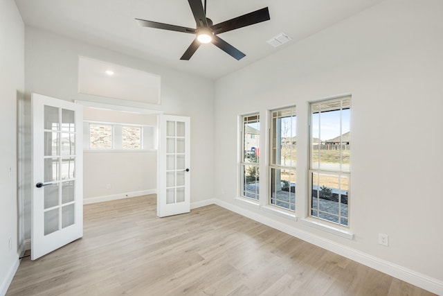 empty room featuring light hardwood / wood-style flooring, ceiling fan, and french doors