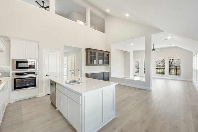 kitchen with sink, appliances with stainless steel finishes, an island with sink, ceiling fan, and white cabinets