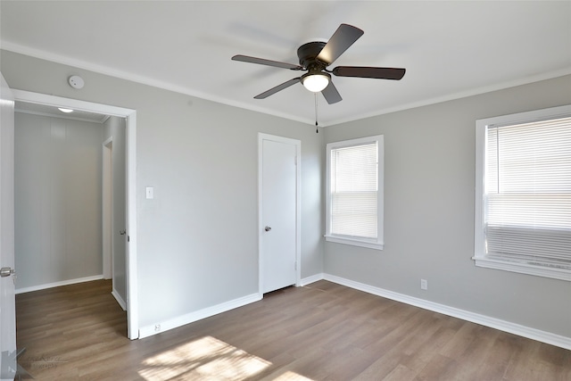 unfurnished bedroom featuring crown molding, wood-type flooring, and ceiling fan