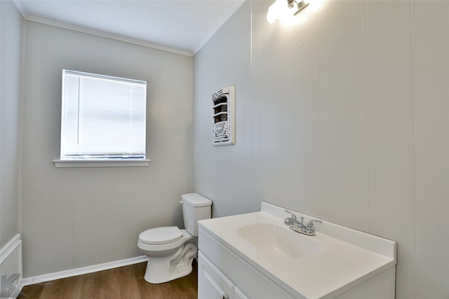 bathroom with toilet, hardwood / wood-style floors, vanity, and ornamental molding