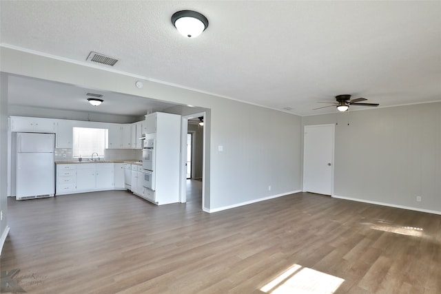 unfurnished living room featuring a textured ceiling, light hardwood / wood-style floors, and ceiling fan