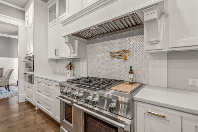 kitchen featuring dark wood-type flooring, appliances with stainless steel finishes, white cabinets, and tasteful backsplash