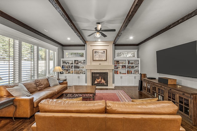 living room with dark wood-type flooring, ceiling fan, beamed ceiling, and ornamental molding