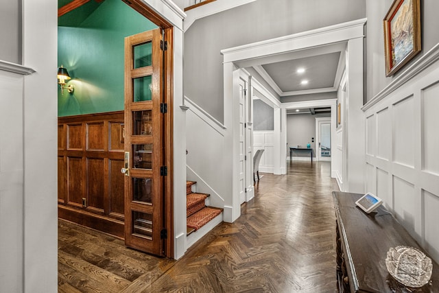 foyer featuring ornamental molding and dark parquet flooring