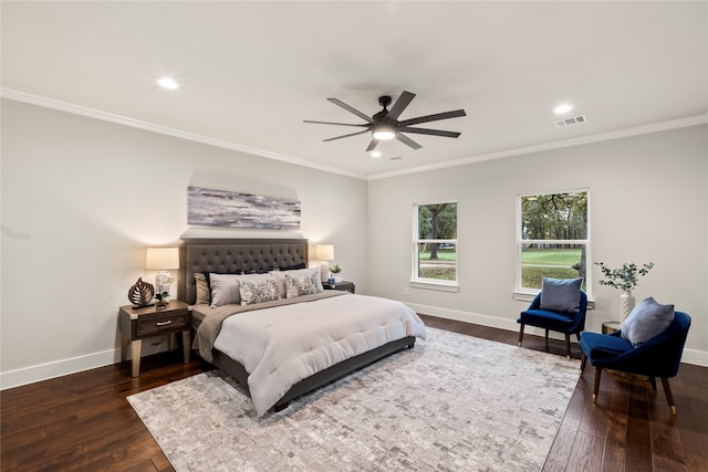 bedroom featuring dark hardwood / wood-style flooring, ceiling fan, and crown molding