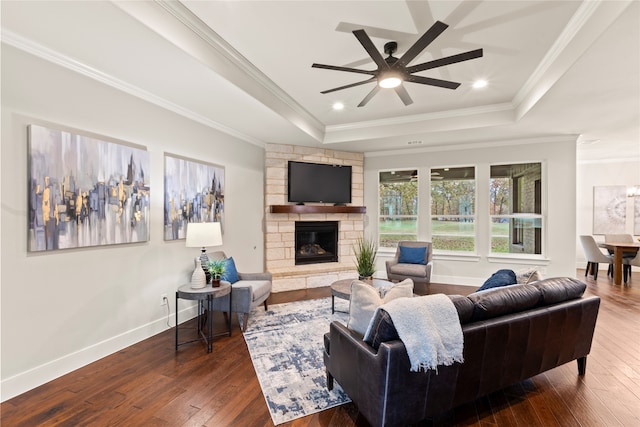 living room featuring ornamental molding, a tray ceiling, and dark wood-type flooring