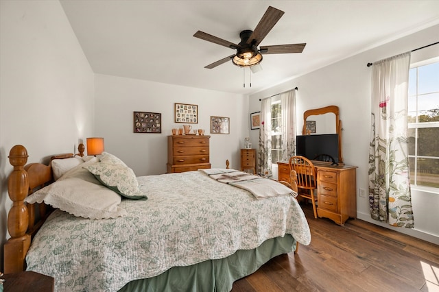 bedroom featuring ceiling fan, multiple windows, and hardwood / wood-style flooring