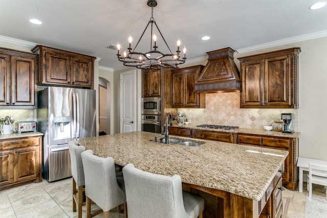 kitchen with stainless steel appliances, an inviting chandelier, sink, a kitchen island with sink, and premium range hood