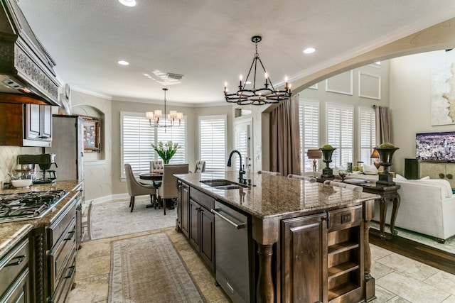 kitchen featuring a wealth of natural light, a center island with sink, sink, and custom exhaust hood