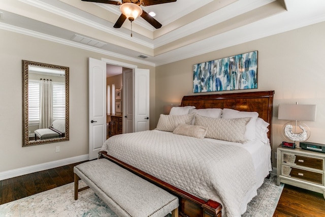 bedroom with a raised ceiling, dark wood-type flooring, ceiling fan, and crown molding