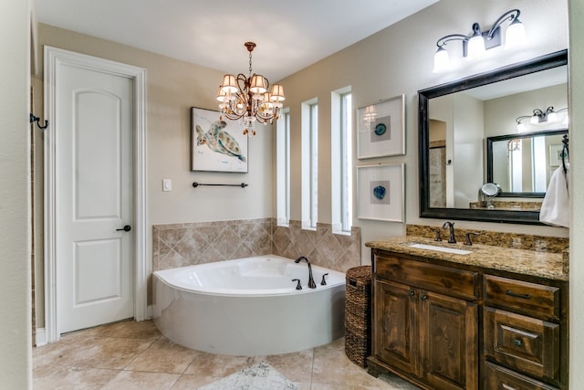 bathroom with tile patterned flooring, a wealth of natural light, a notable chandelier, vanity, and a tub to relax in