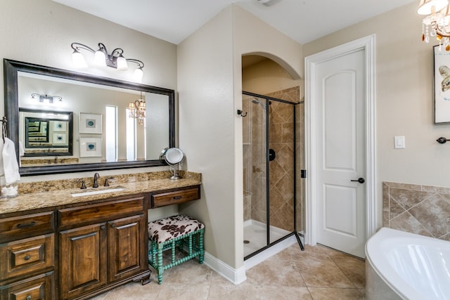 bathroom featuring vanity, tile patterned flooring, plus walk in shower, and a notable chandelier