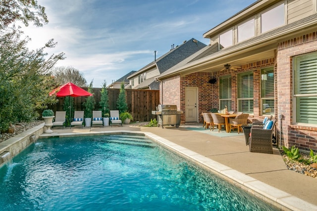 view of pool with grilling area, pool water feature, ceiling fan, and a patio