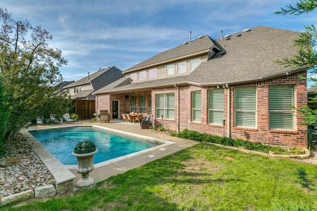 rear view of property featuring a patio and a yard