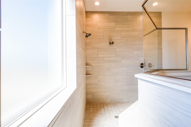 bathroom with a tile shower and tile patterned floors