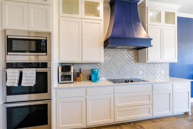 kitchen featuring crown molding, white cabinets, custom range hood, and stainless steel appliances