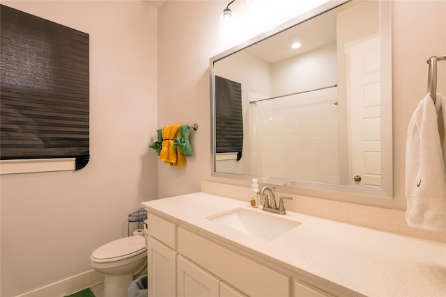 bathroom featuring toilet, vanity, and a shower