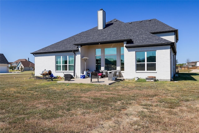 rear view of property with a yard and a patio area