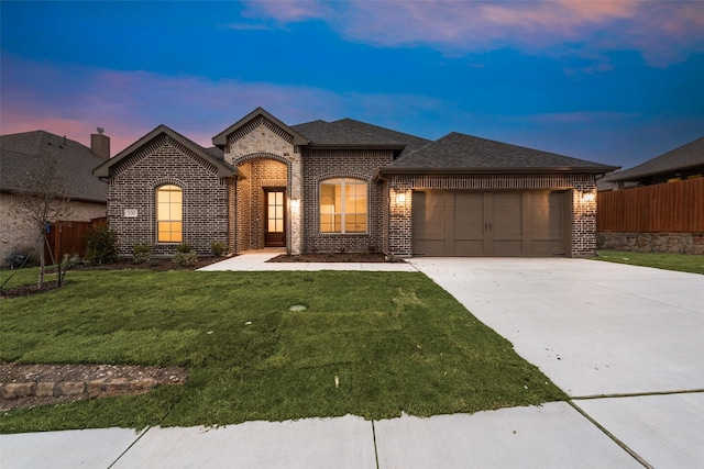 view of front facade with a garage and a lawn