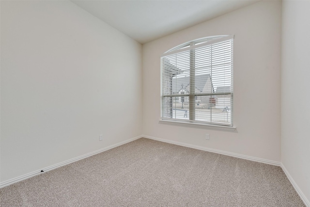 empty room with lofted ceiling and carpet flooring